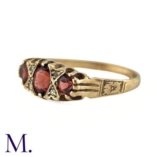 7 - A Garnet and Diamond Ring, in 9k yellow gold, the three oval cut Garnets punctuated by pairs of roun... 