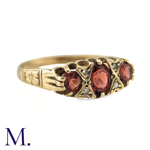 7 - A Garnet and Diamond Ring, in 9k yellow gold, the three oval cut Garnets punctuated by pairs of roun... 