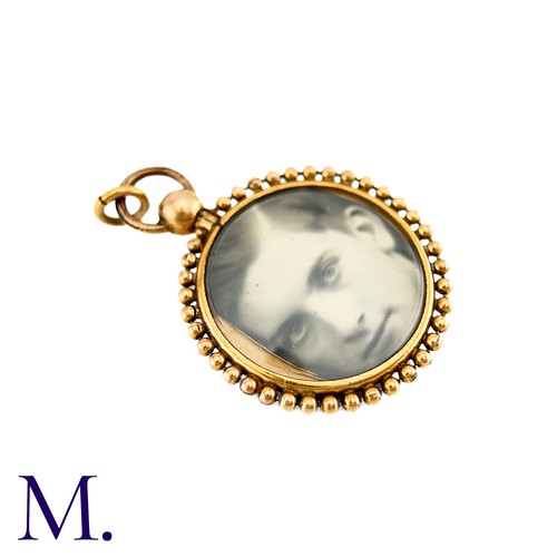 71 - An Antique Locket Pendant in yellow gold, the circular frame set either side with a photograph.  (un... 