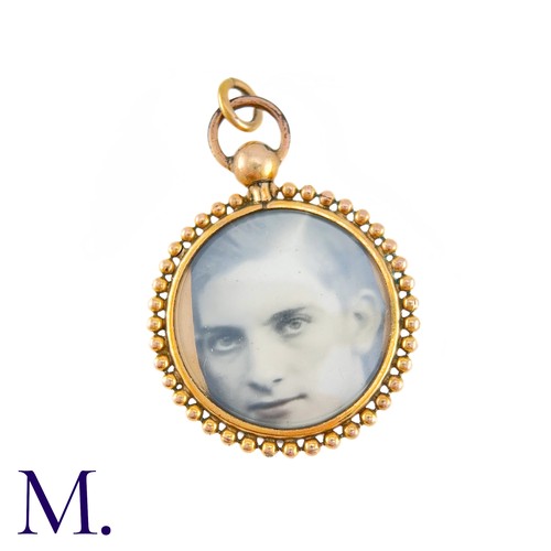 71 - An Antique Locket Pendant in yellow gold, the circular frame set either side with a photograph.  (un... 