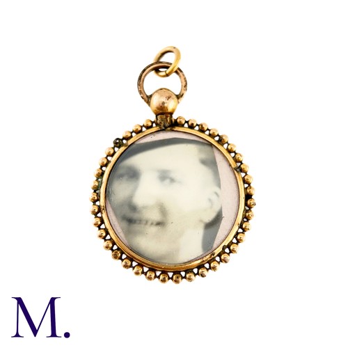 71 - An Antique Locket Pendant in yellow gold, the circular frame set either side with a photograph.  (un... 