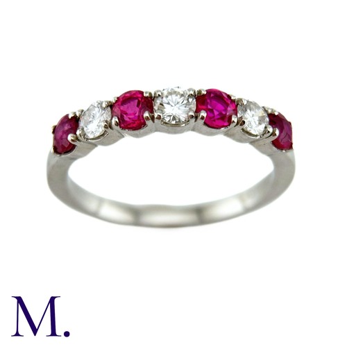 34 - A Ruby And Diamond Seven Stone Ring in platinum, set with an alternating row of four round cut rubie... 