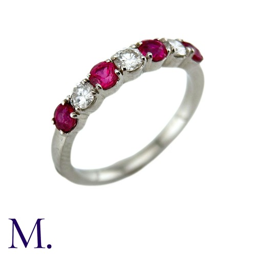 34 - A Ruby And Diamond Seven Stone Ring in platinum, set with an alternating row of four round cut rubie... 