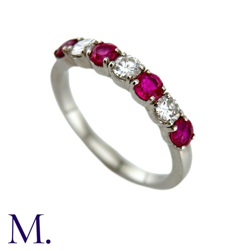 34 - A Ruby And Diamond Seven Stone Ring in platinum, set with an alternating row of four round cut rubie... 