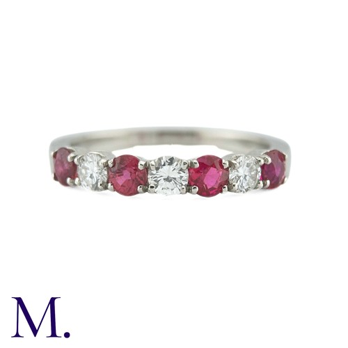 34 - A Ruby And Diamond Seven Stone Ring in platinum, set with an alternating row of four round cut rubie... 