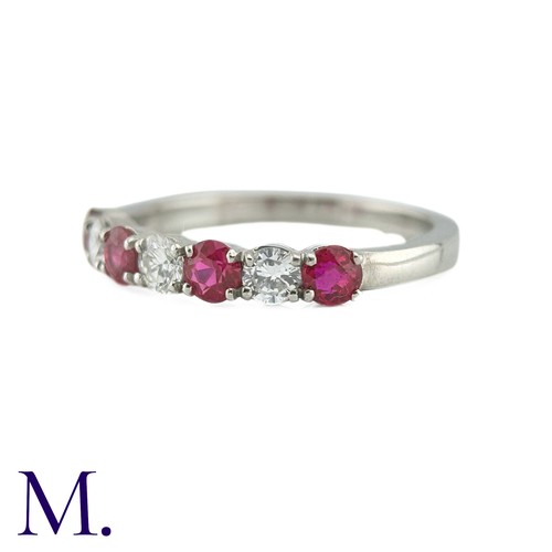 34 - A Ruby And Diamond Seven Stone Ring in platinum, set with an alternating row of four round cut rubie... 