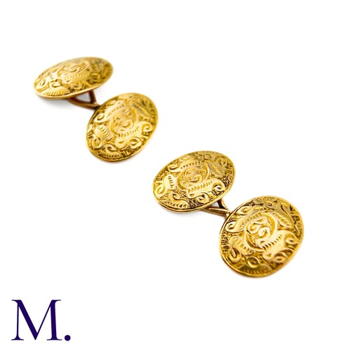 52 - A Pair Of Engraved Oval Cufflinks in 15k yellow gold,  the oval form with engraved celtic pattern de... 