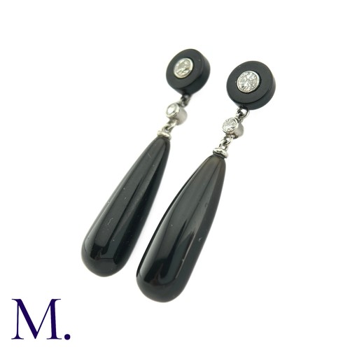 73 - A Pair Of Onyx And Diamond Drop Earrings in platinum the tops a polished onyx disc set to the centre... 