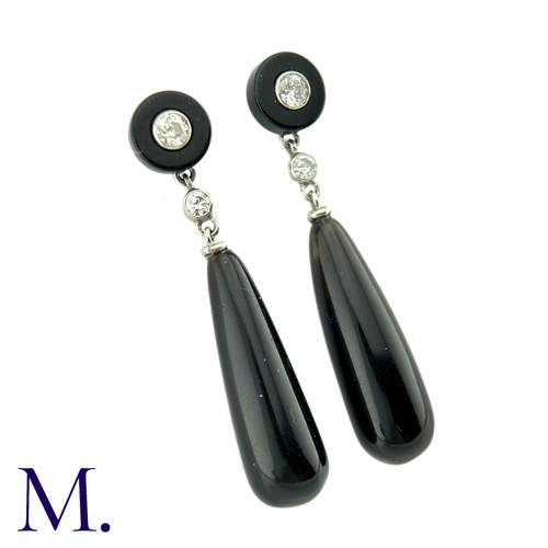 73 - A Pair Of Onyx And Diamond Drop Earrings in platinum the tops a polished onyx disc set to the centre... 