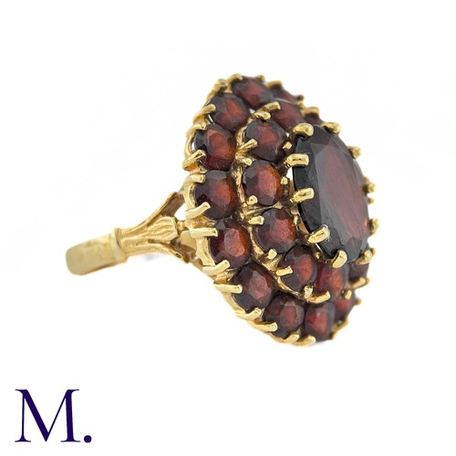 288 - NO RESERVE - A Garnet Cluster Ring in 18k yellow gold, designed as a central oval cut garnet surroun... 