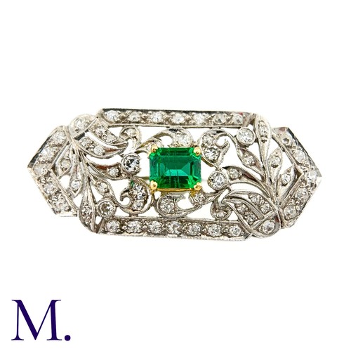 79 - An Art Deco Emerald and Diamond Brooch in 18K white gold.  Set with an rectangular emerald to the ce... 