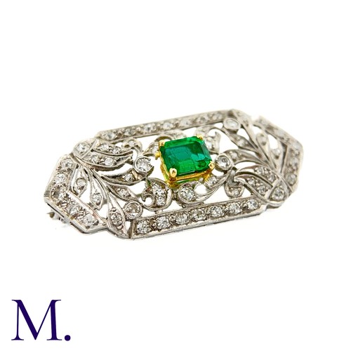 79 - An Art Deco Emerald and Diamond Brooch in 18K white gold.  Set with an rectangular emerald to the ce... 