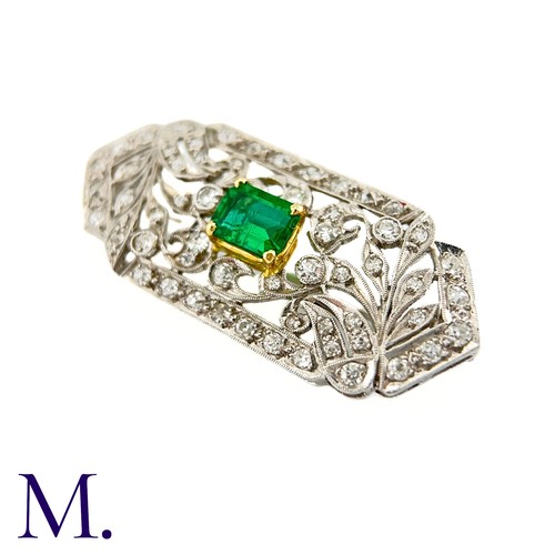 79 - An Art Deco Emerald and Diamond Brooch in 18K white gold.  Set with an rectangular emerald to the ce... 