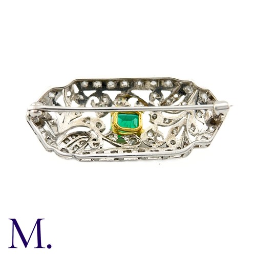 79 - An Art Deco Emerald and Diamond Brooch in 18K white gold.  Set with an rectangular emerald to the ce... 