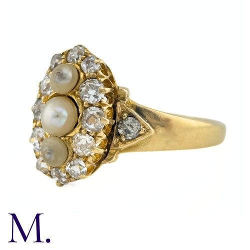 26 - A Pearl And Diamond Ring in yellow gold, the navette form set to the centre with a trio of pearls su... 