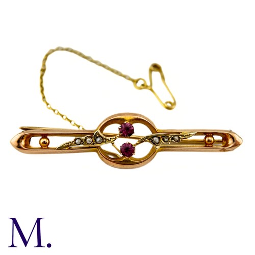 29 - A Ruby And Pearl Brooch in 9k yellow gold, centrally set with two round cut rubies, with pearl set f... 