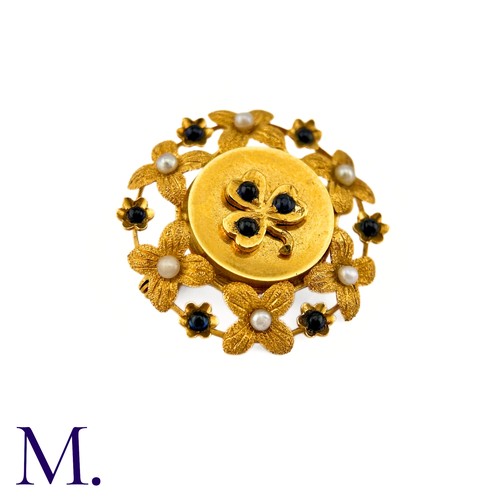 286 - A Sapphire And Pearl Clover Brooch in 9k yellow gold, circular brooch with a clover motif set with c... 