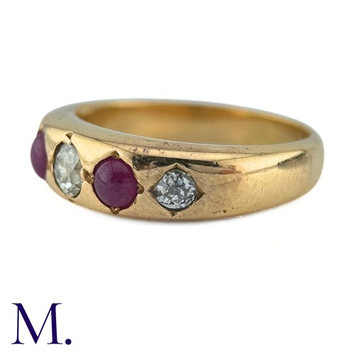 41 - A Ruby And Diamond Gypsy Ring in yellow gold, set with three old cut diamonds punctuated by two cabo... 