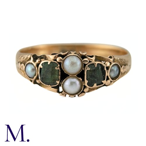 38 - An Antique Emerald And Pearl Ring in 15k yellow gold, set with two step cut emeralds and accented by... 