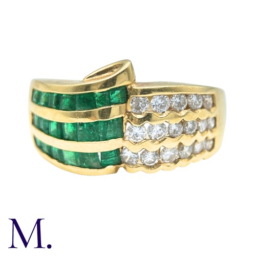 303 - An Emerald And Diamond Ring in 18k yellow gold, set with three rows of channel set emeralds and roun... 