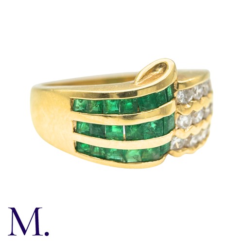 303 - An Emerald And Diamond Ring in 18k yellow gold, set with three rows of channel set emeralds and roun... 