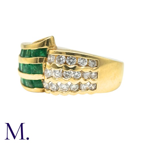303 - An Emerald And Diamond Ring in 18k yellow gold, set with three rows of channel set emeralds and roun... 