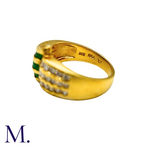 303 - An Emerald And Diamond Ring in 18k yellow gold, set with three rows of channel set emeralds and roun... 