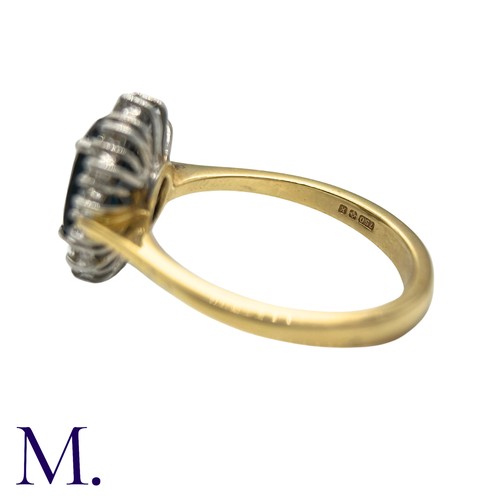 30 - A Sapphire And Diamond Cluster Ring in 18k yellow gold, set with an oval cut sapphire of approximate... 