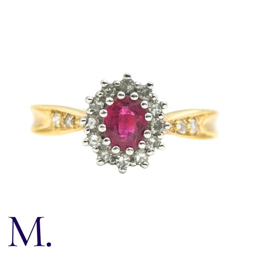 29 - A Ruby And Diamond Cluster Ring in 18k yellow gold, set with an oval cut ruby set within a round cut... 