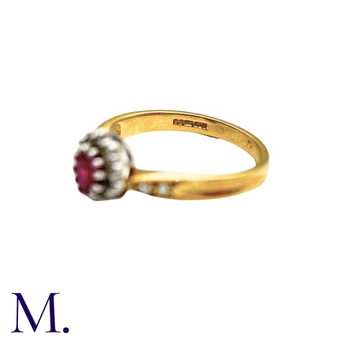 29 - A Ruby And Diamond Cluster Ring in 18k yellow gold, set with an oval cut ruby set within a round cut... 