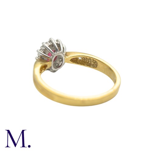 29 - A Ruby And Diamond Cluster Ring in 18k yellow gold, set with an oval cut ruby set within a round cut... 