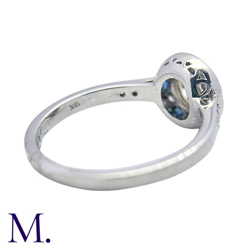 229 - A Diamond And Sapphire Target Cluster Ring in 18k white gold, set with a principal round cut diamond... 