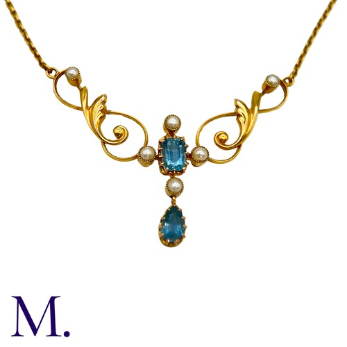 40 - An Aquamarine And Pearl Necklace in 15k yellow gold, set with a step cut aquamarine and pearls suspe... 