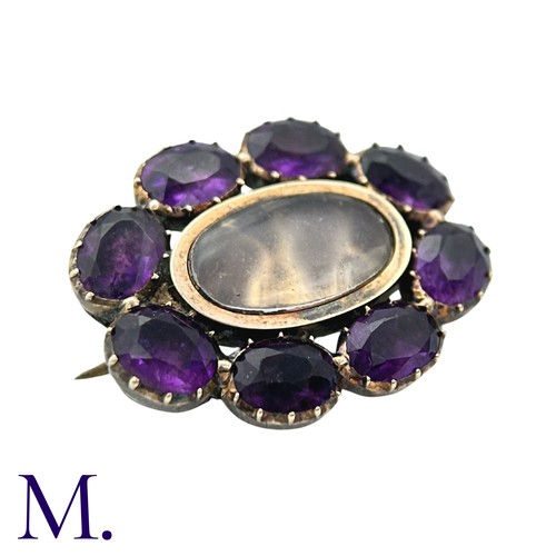 27 - An Amethyst And Glass Brooch in yellow gold, comprising a cluster of oval cut amethyst around a glas... 