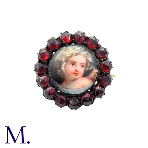 36 - A Garnet And Enamel Brooch in yellow metal, set with a cluster of round cut garnet around an enamel ... 