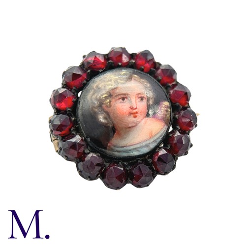 36 - A Garnet And Enamel Brooch in yellow metal, set with a cluster of round cut garnet around an enamel ... 