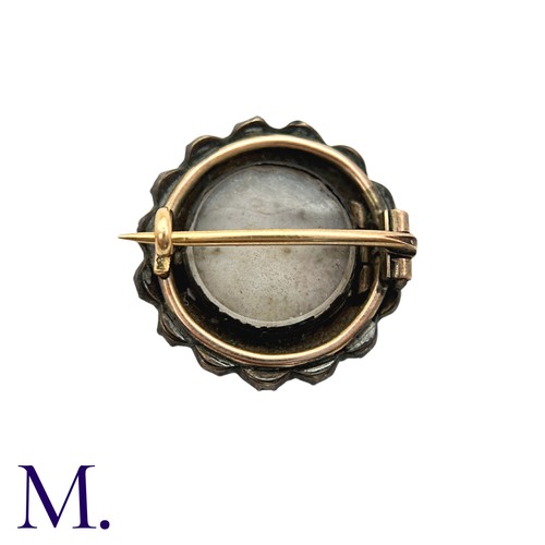36 - A Garnet And Enamel Brooch in yellow metal, set with a cluster of round cut garnet around an enamel ... 