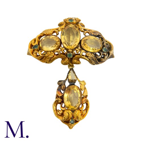 42 - A Citrine And Emerald Brooch in yellow gold, the ornate scrolling body set with oval cut citrine and... 