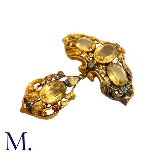 42 - A Citrine And Emerald Brooch in yellow gold, the ornate scrolling body set with oval cut citrine and... 
