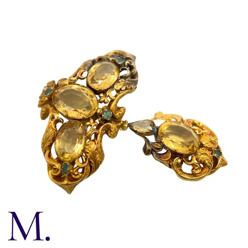 42 - A Citrine And Emerald Brooch in yellow gold, the ornate scrolling body set with oval cut citrine and... 