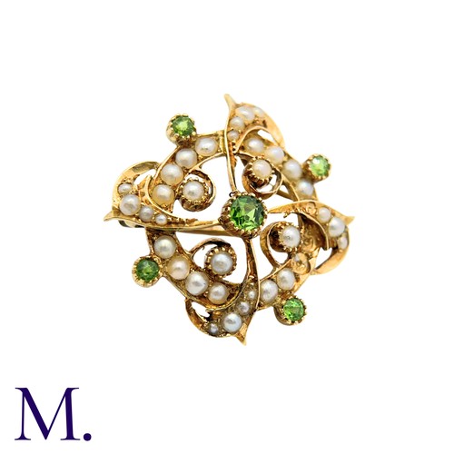214 - A Peridot And Pearl Brooch in 15k yellow gold, the circular form set with pearls and peridot with sc... 