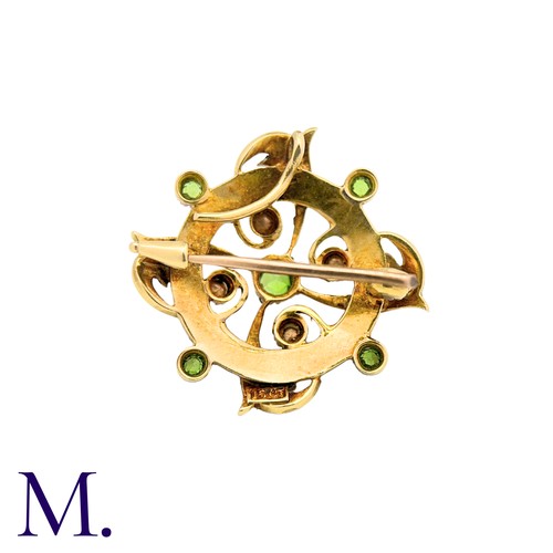 214 - A Peridot And Pearl Brooch in 15k yellow gold, the circular form set with pearls and peridot with sc... 