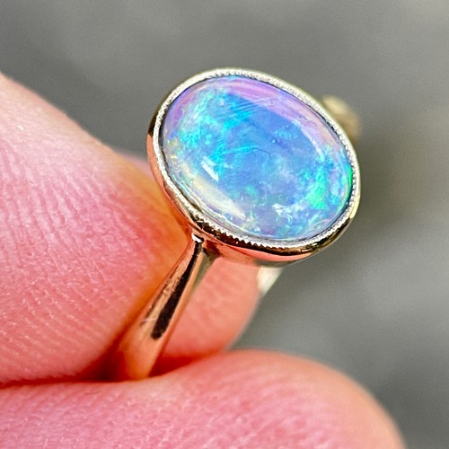 3 - An Opal Ring in 9k yellow gold, set with a cabochon opal. Stamped 9ct.

Size: I1/2
Weight: 1.8g
