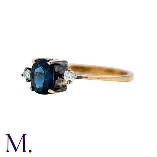 17 - A Sapphire And Diamond Ring in 14k yellow gold, set with an oval cut sapphire between two round cut ... 