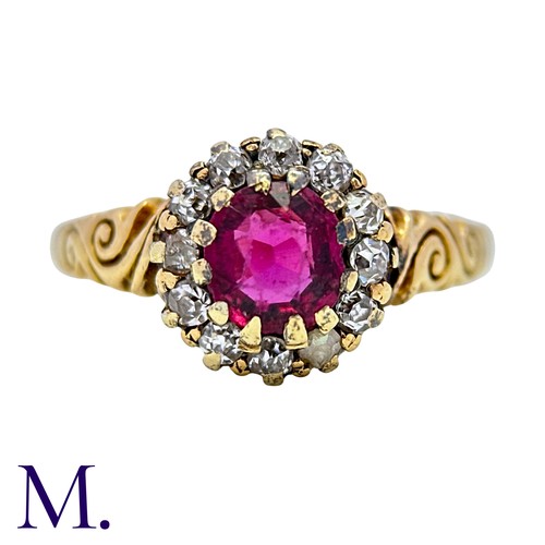 5 - A Ruby And Diamond Cluster Ring in 18k yellow gold, set with a round cut ruby within an old cut diam... 