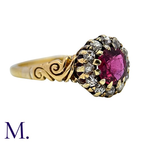 5 - A Ruby And Diamond Cluster Ring in 18k yellow gold, set with a round cut ruby within an old cut diam... 