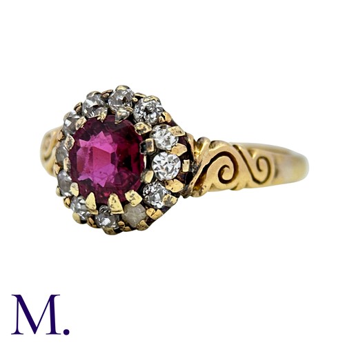 5 - A Ruby And Diamond Cluster Ring in 18k yellow gold, set with a round cut ruby within an old cut diam... 