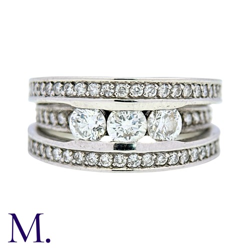 52 - A Diamond Ring in 18k white gold, set with three principal round cut diamonds, set to three pavé set... 