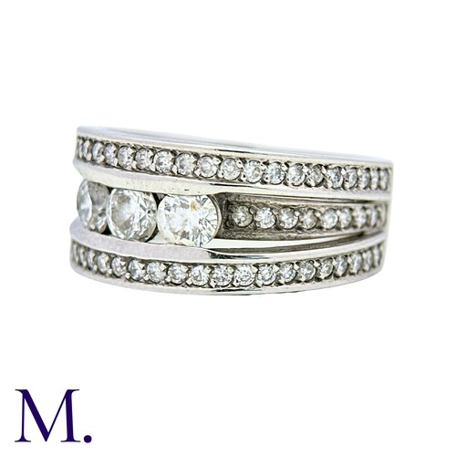 52 - A Diamond Ring in 18k white gold, set with three principal round cut diamonds, set to three pavé set... 