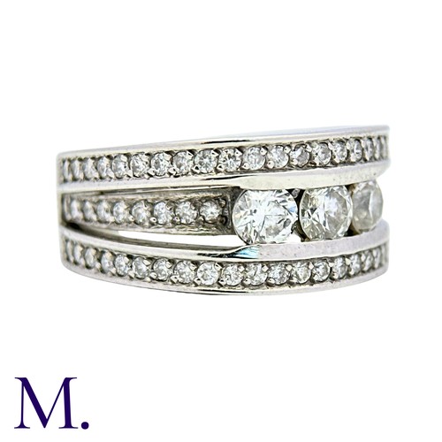 52 - A Diamond Ring in 18k white gold, set with three principal round cut diamonds, set to three pavé set... 